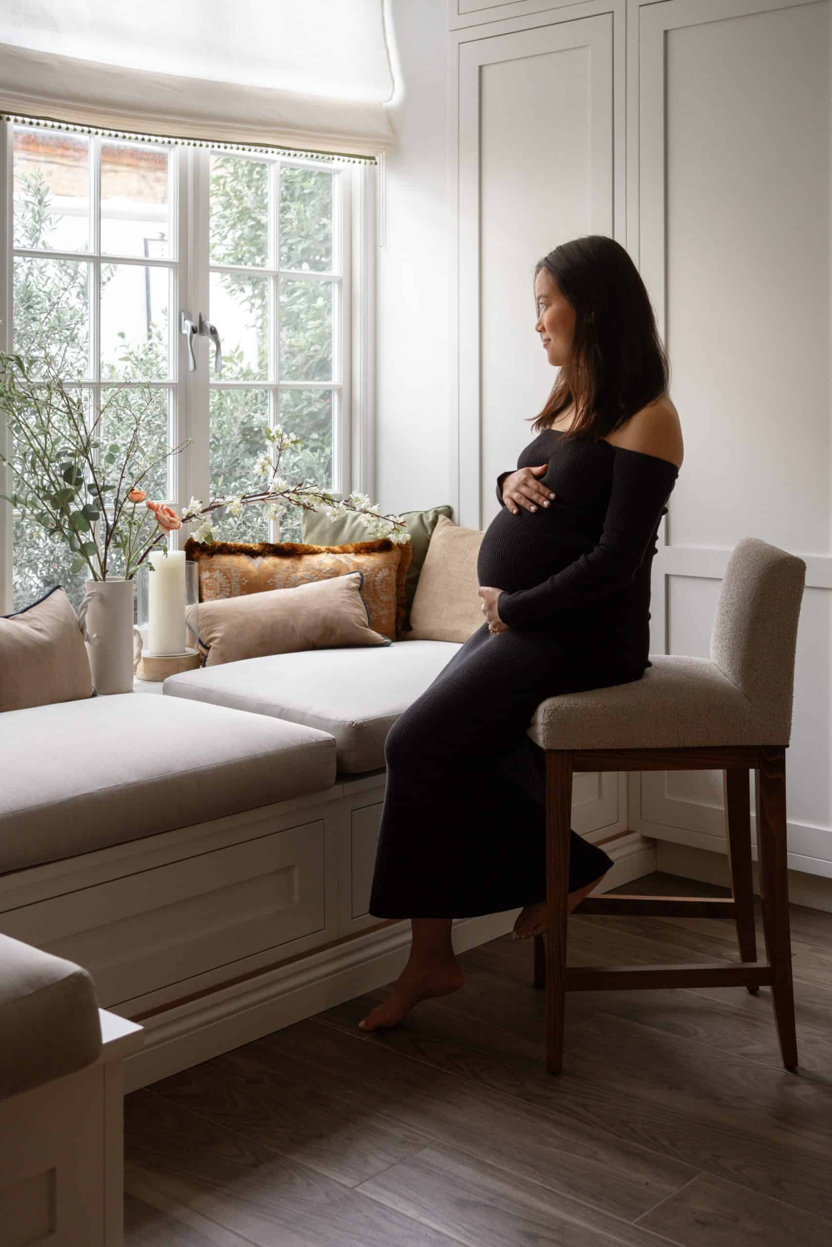 photo of pregnant woman standing by window taken by london maternity photography