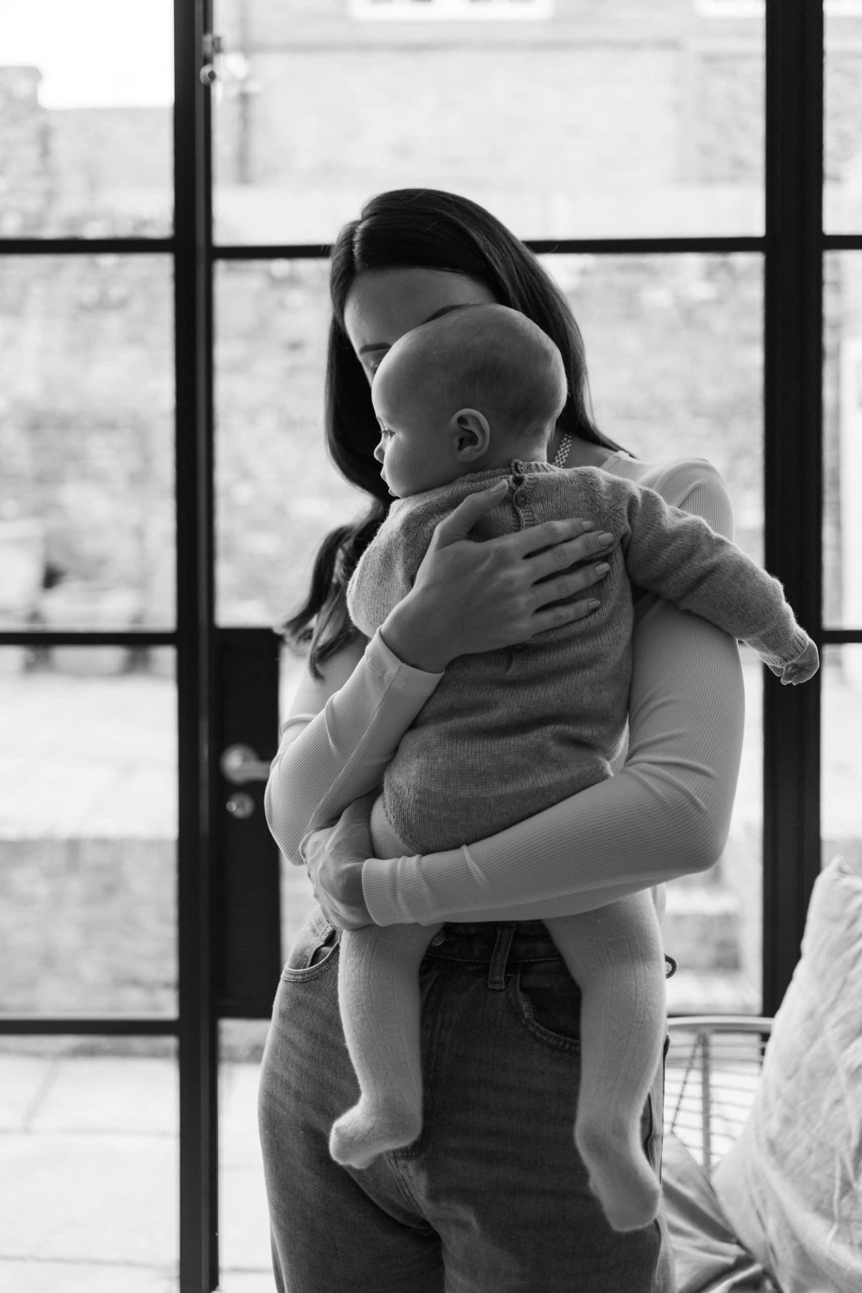 black and white image of mother holding baby 
